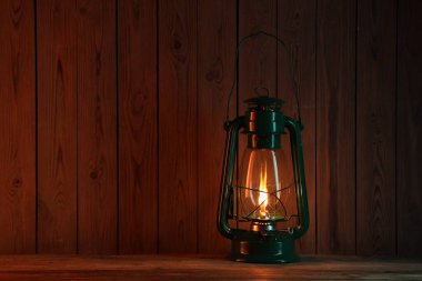 Ahşap masada eski bir gaz lambası, metin için yer var.