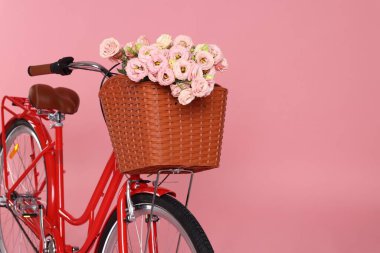 Pembe arka planda bir sepet güzel çiçekli bisiklet. Metin için boşluk
