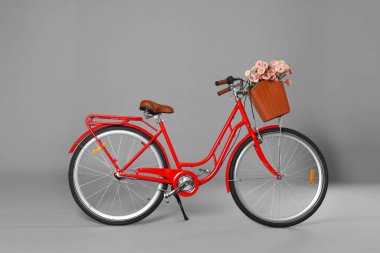 Gri arka planda bir sepet güzel çiçekli bisiklet.