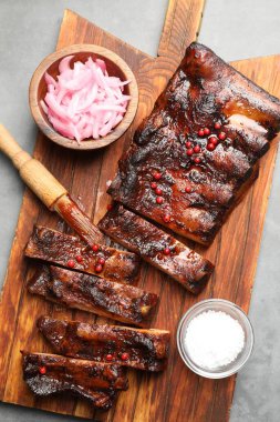 Lezzetli kaburgalar, soğan, tuz ve fırça gri masada, üst manzara