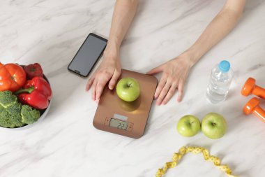 Kadın mutfak terazisinde ağırlıklı beyaz mermer masa, üst manzara