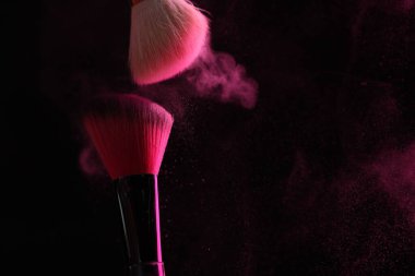 Siyah arka planda pembe göz farlı makyaj fırçaları, yakın plan. Metin için boşluk