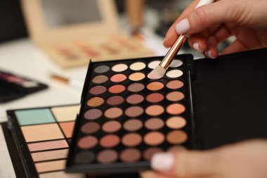 Makyaj masasında fırça ve göz falı olan kadın, yakın plan.