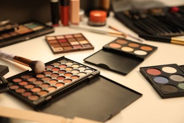 Tuvalet masasında farklı makyaj ürünleri ve fırçalar var.