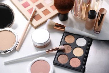 Beyaz masadaki farklı makyaj ürünleri.