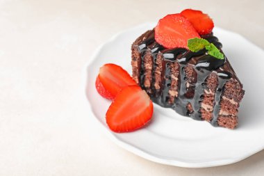 Çikolatalı kek, beyaz masada çilek ile servis edilir, yakın plan. Metin için boşluk