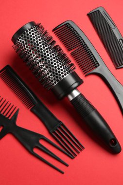 Kırmızı arka planda farklı kuaför aletleri, düz yatıyordu