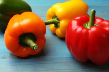 Mavi ahşap masada taze dolmalık biberler, yakın plan.