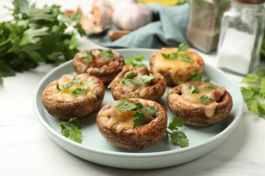 Lezzetli mantarlar ve baharatlar beyaz mermer masada, yakın plan.