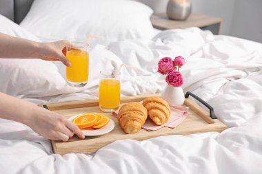 Kadın yatakta nefis bir kahvaltı yapıyor, yakın plan.