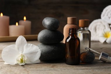 Kozmetik ürünleri ve spa taşlarıyla ahşap masaya yakın plan kompozisyon.
