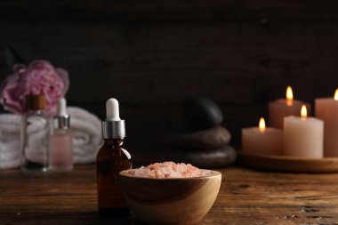 Siyah arkaplana karşı ahşap tablonun üzerinde kozmetik ürünleri olan spa kompozisyonu, yakın plan