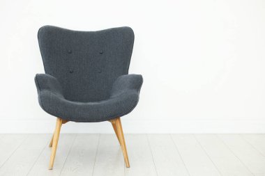 Beyaz duvarın yanında rahat bir koltuk, metin için boşluk.