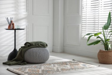 Ev dekoru ve ekose desenli şık örülmüş bir puf. Metin için boşluk