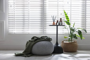 Ev dekoru ve ekose desenli şık örülmüş bir puf. Metin için boşluk