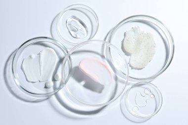 Petri kabında farklı kozmetik ürünleri beyaz arka planda, düz yerde