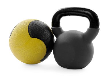 Beyaza izole edilmiş ilaç topu ve kettlebell.