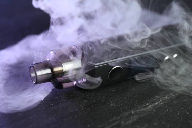 Siyah masada modern elektronik sigara içme cihazı, yakın plan.
