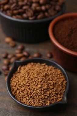 Farklı tipte kahve ve fasulyeler ahşap masada, yakın plan.