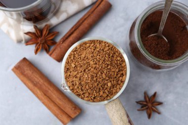 Gri masada farklı türde hazır kahve ve baharatlar var.