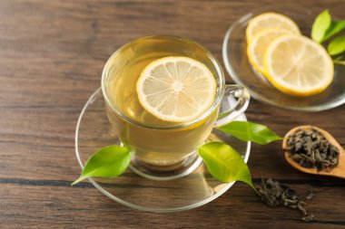 Limonlu yeşil çay ve ahşap masa yaprakları, yakın çekim