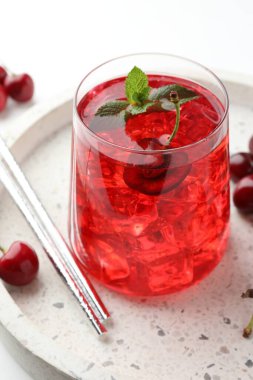 Buzlu vişneli soda, nane ve böğürtlenler beyaz masada, yakın plan.