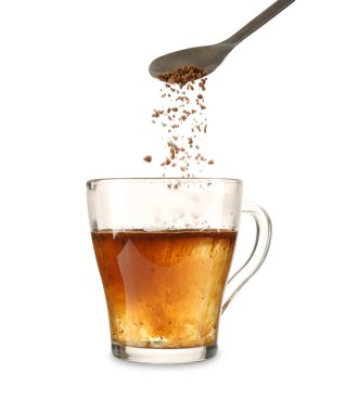 Kaşıktan cam fincana granüle edilmiş kahve ekliyorum. Kaynatılmış su beyaz, yakın plan.