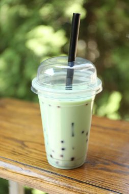 Tahta masada plastik bardakta lezzetli sütlü çay.