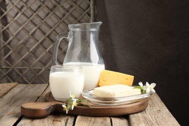Tahta masada farklı taze süt ürünleri ve çiçekler.