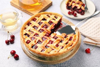 Gri desenli masada vişneli turta ve böğürtlen. Yakın plan.