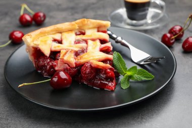 Gri masadaki lezzetli vişneli turta ve böğürtlen, yakın plan.