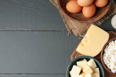 Gri ahşap masa üzerinde farklı süt ürünleri ve yumurtalar, düz yatak. Metin için boşluk