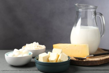 Gri ahşap masada farklı süt ürünleri, yakın plan.