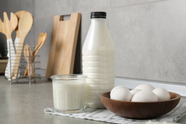 Mutfaktaki gri desenli masada süt ürünleri ve yumurtalar.