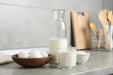 Mutfaktaki gri desenli masada farklı süt ürünleri ve yumurtalar.