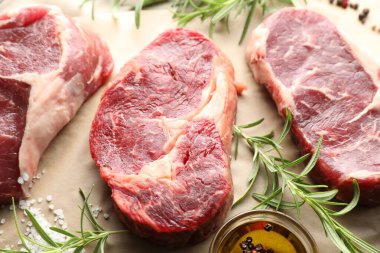 Parşömen kağıdındaki çiğ et parçaları ve baharatlar.