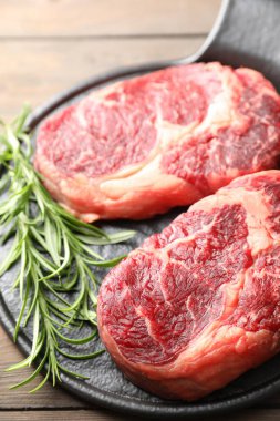 Çiğ et ve biberiye parçaları masada, yakın plan.