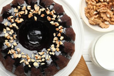 Fındıklı çikolatalı kek ve beyaz ahşap masada bir bardak süt.