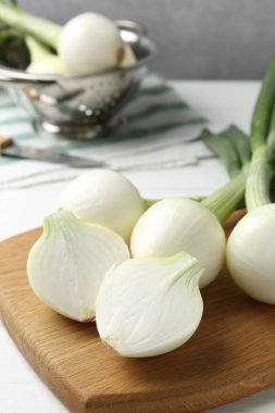 Taze taze taze soğanlar beyaz ahşap masada, yakın plan.