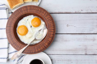 Geleneksel Asya kahvaltısı, yarısı haşlanmış yumurta, kahve ve kızarmış ekmek beyaz ahşap masada, düz yatıyordu. Metin için boşluk