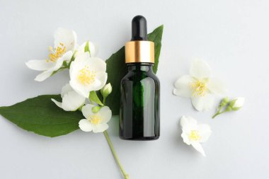 Kozmetik ürünleri ve yasemin çiçekleri arka planda, düz yatıyordu