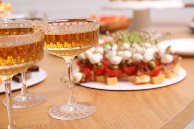 Açık büfe menüsü. Bir bardak köpüklü şarap ve lezzetli aperatifler masada, yakın plan.
