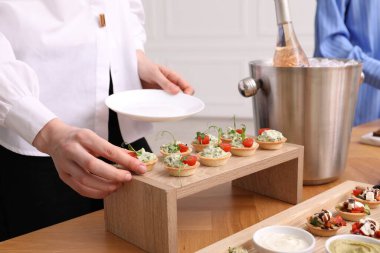 Açık büfe menüsü. Lezzetli tartı masadan alan kadın, yakın plan.