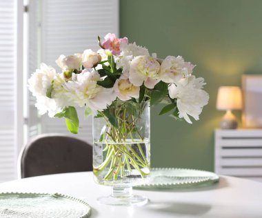 Yemek odasında bir vazo çiçekli güzel bir masa.