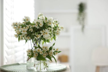 İçerideki masada vazoda duran bir buket güzel yasemin çiçeği. Metin için boşluk