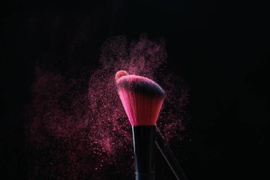Siyah arka planda pembe göz farlı makyaj fırçaları, yakın plan