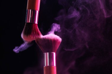 Renkli göz gölgeli makyaj fırçaları siyah arka planda neon ışıkları, yakın plan