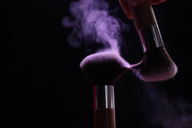 Siyah arka planda mor göz farlı makyaj fırçaları, yakın plan