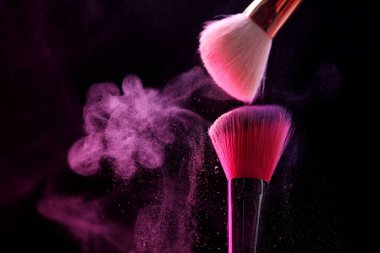Siyah arka planda pembe göz farlı makyaj fırçaları, yakın plan. Metin için boşluk