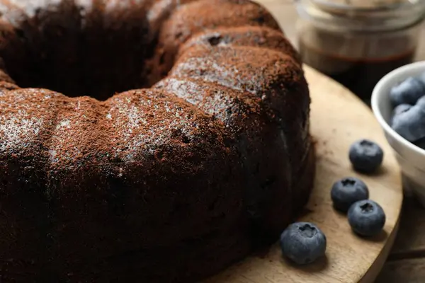 Ahşap masada yaban mersinli lezzetli çikolatalı kek, yakın plan.